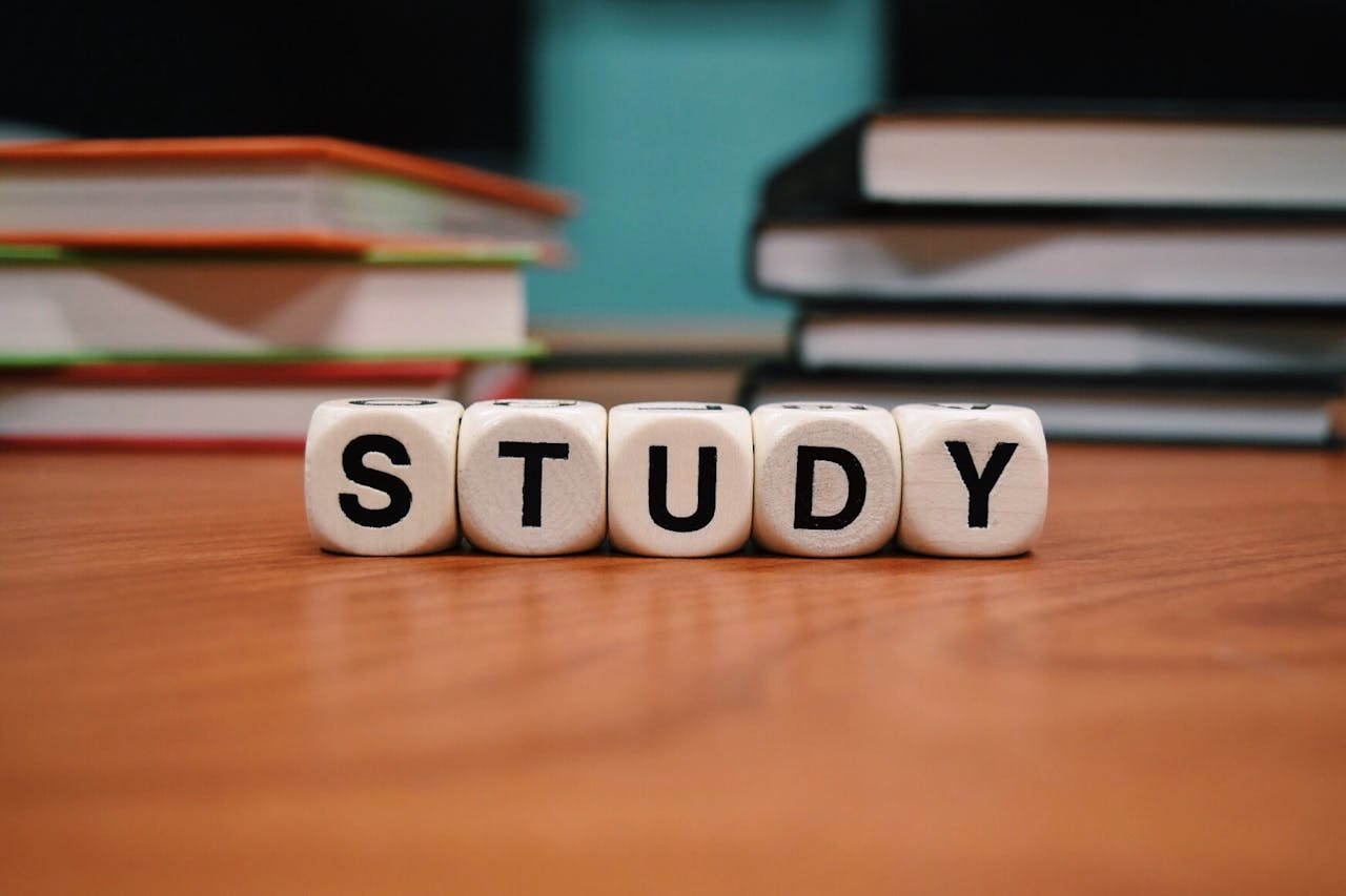 digital Close-up of study blocks and stacked books on a wooden desk, symbolizing education and learning.